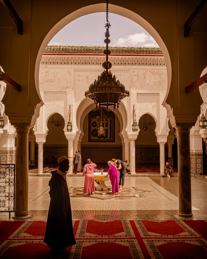Photo d'un riad au Maroc avec des personnes près de la fontaine du patio